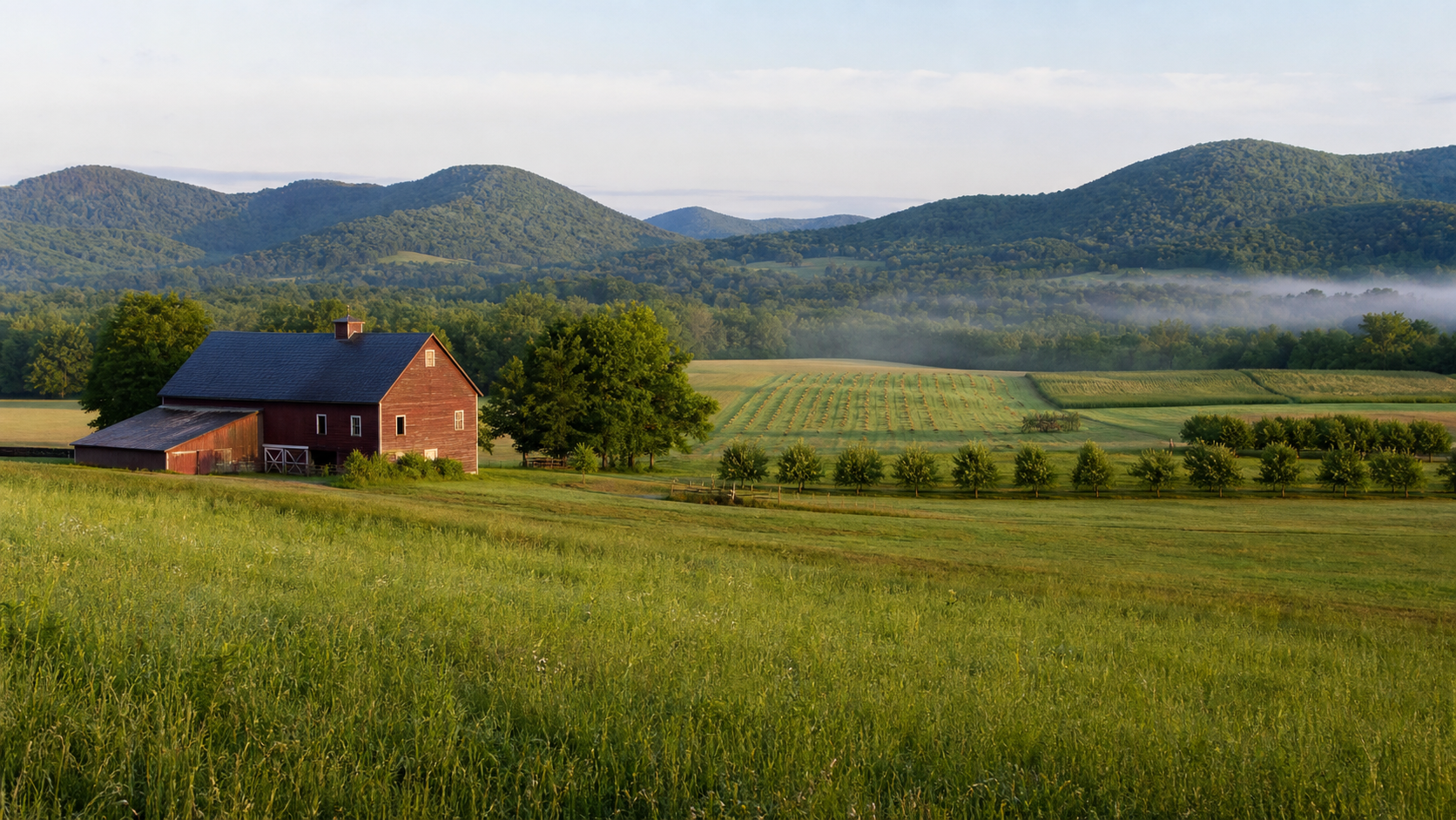 Rolling fields, a red barn, and wooded hills in the Berkshires